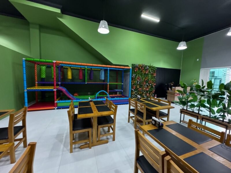 Família desfrutando de um buffet no Gastrô Siqueira, com espaço kids ao fundo