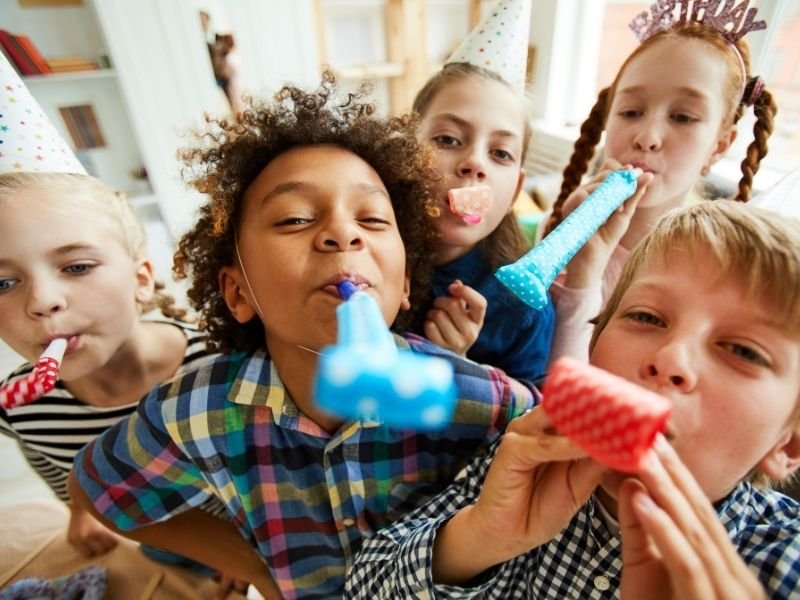 Crianças se divertindo em uma festa infantil com a presença dos pais.