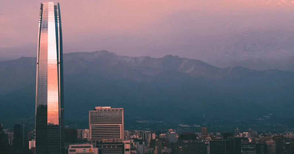 Montanhas cobertas de neve no Chile com vinhedos ao fundo e céu azul claro